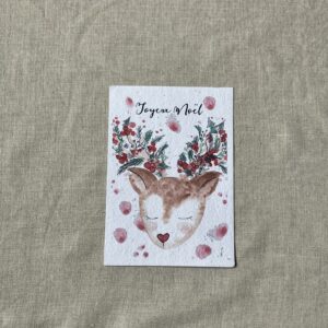 Carte de voeux illustrée à l'aquarelle avec une biche et des bois fleuris portant l'inscription joyeux noël