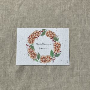 Carte de voeux représentant une couronne d'oranges séchées et de feuilles illustrée à l'aquarelle, au centre le texte meilleurs voeux