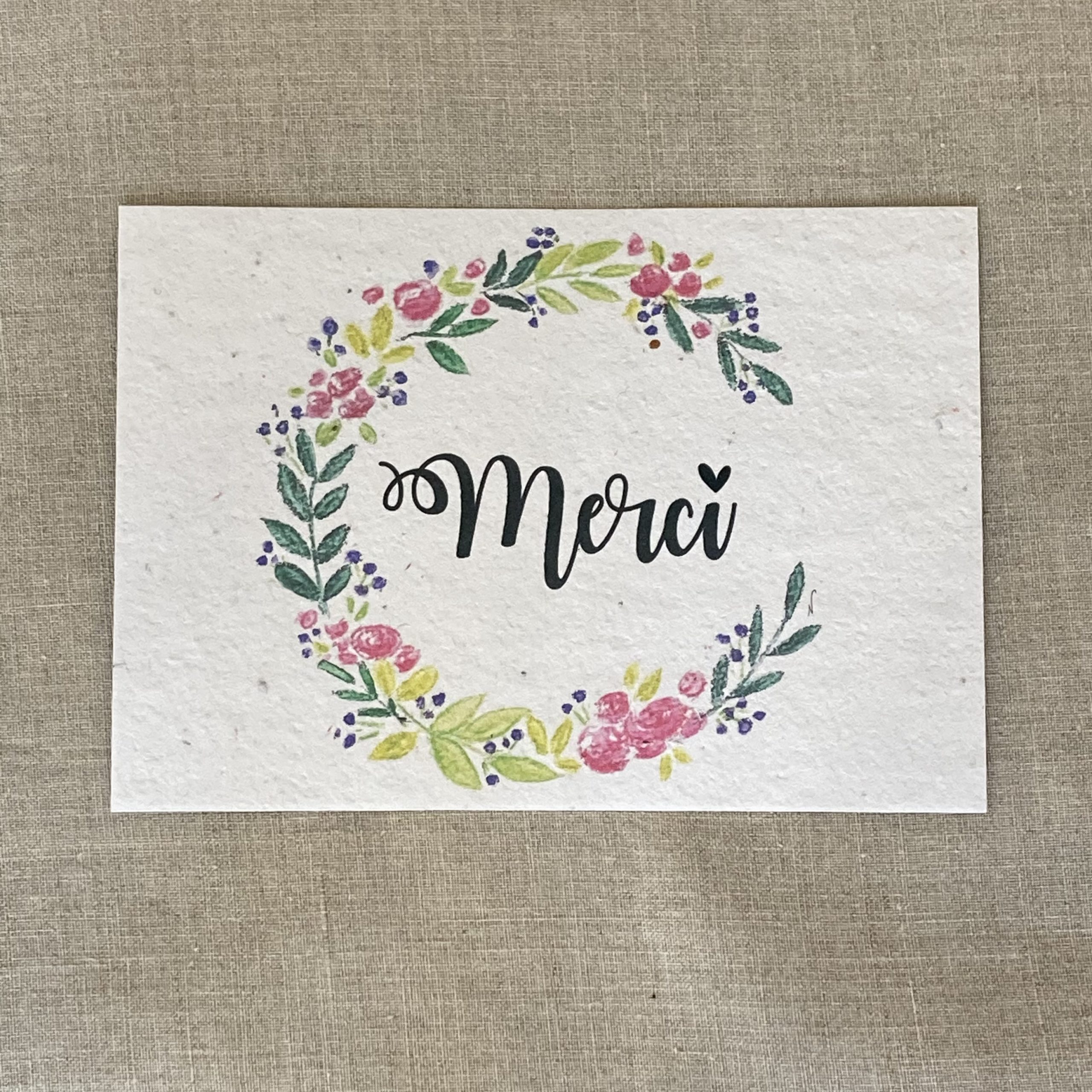 carte à planter illustrée d'une couronne de fleurs et en son centre le texte Merci